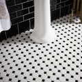 Black and white hexagonal mosaic tile floor featuring classic geometric pattern with jet black skirting tile accents