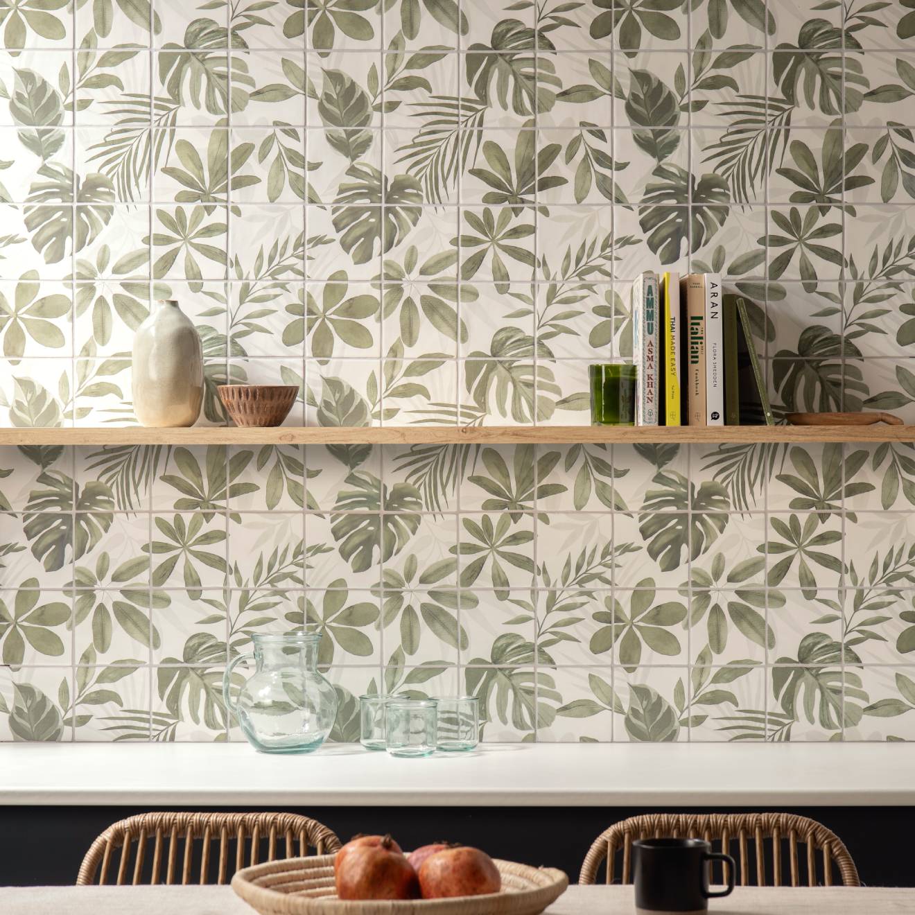 Beige ceramic vase with a slender neck and rounded body on a wooden shelf against leaf-patterned jungle grove 16 tile panel