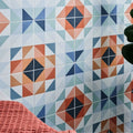 Geometric patterned kaleidoscope porcelain peacock wall tiles with orange blue and white triangular shapes in modern design