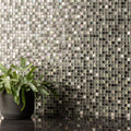 Iridescent kandahar earth and fire mixed mosaic tile wall with black ceramic planter holding green ferns