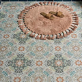 A soft dusty rose-colored round tasselled fringe rug with textured surface from kashmir porcelain earthern collection