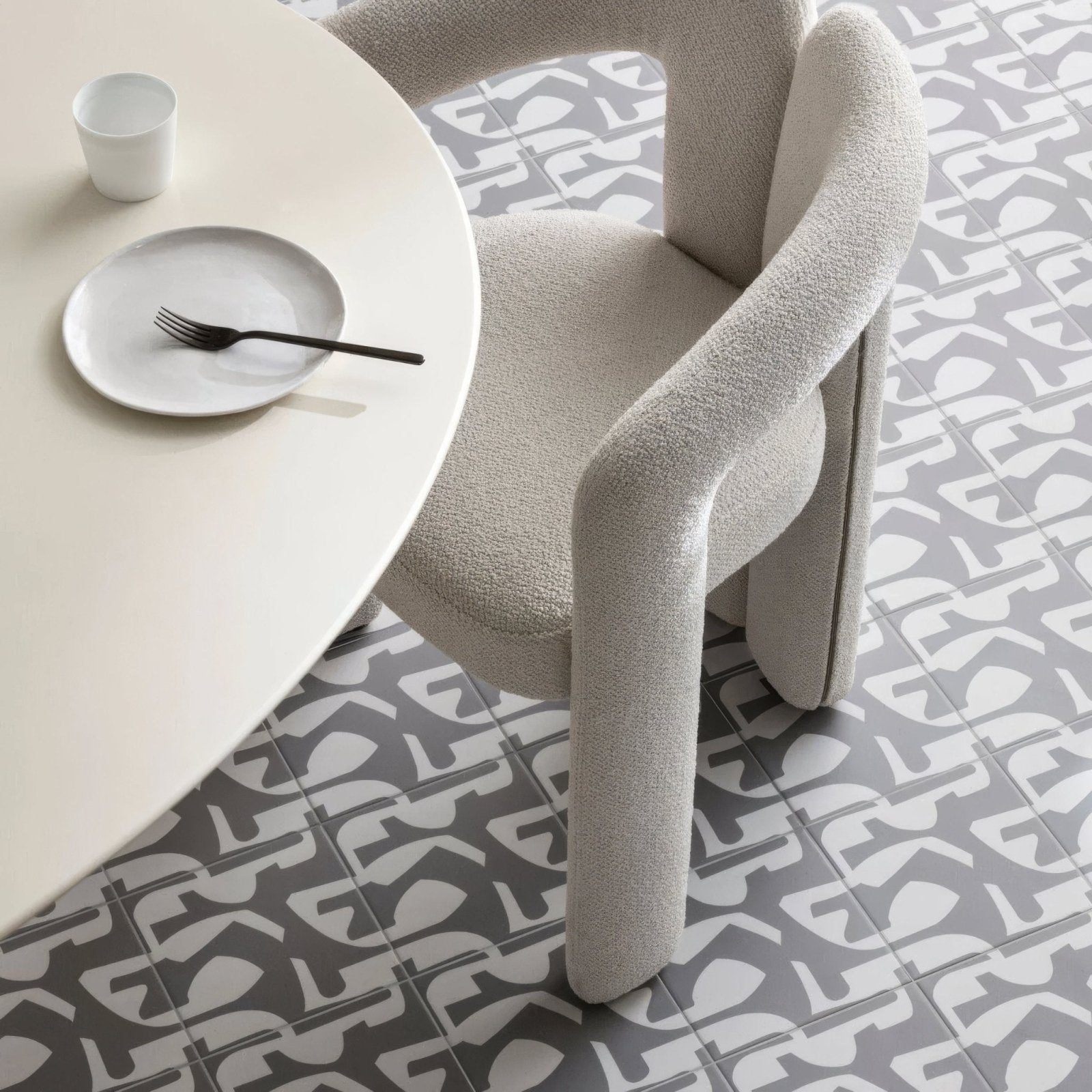 Beige upholstered chair with sculpted tubular legs and rounded backrest from kelly hoppen puzzle grey and white collection
