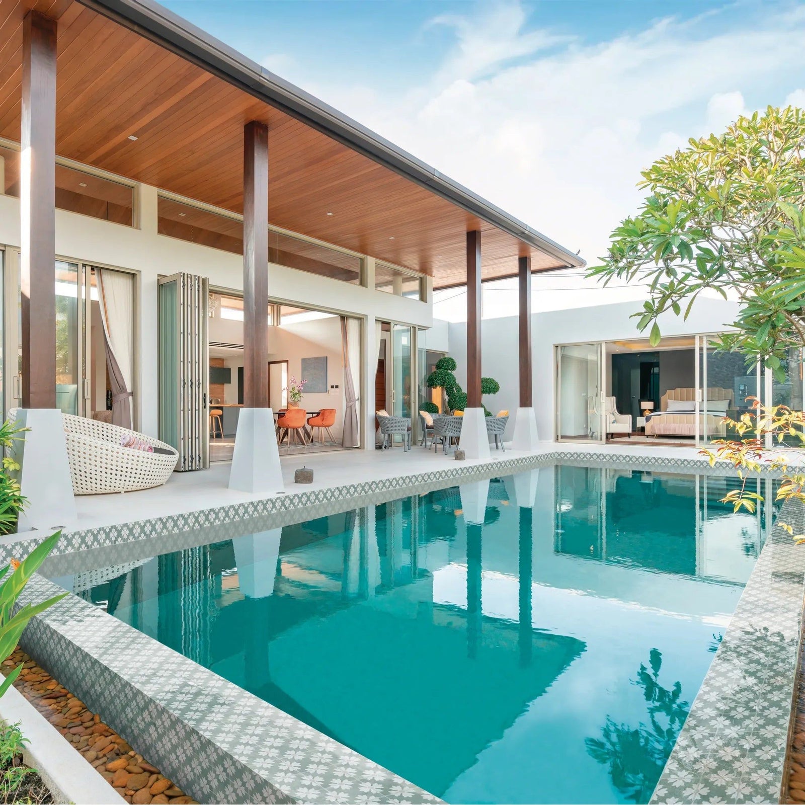 Rectangular turquoise kelmscott coleton blue patterned tile swimming pool with white tiled edges and decorative mosaics