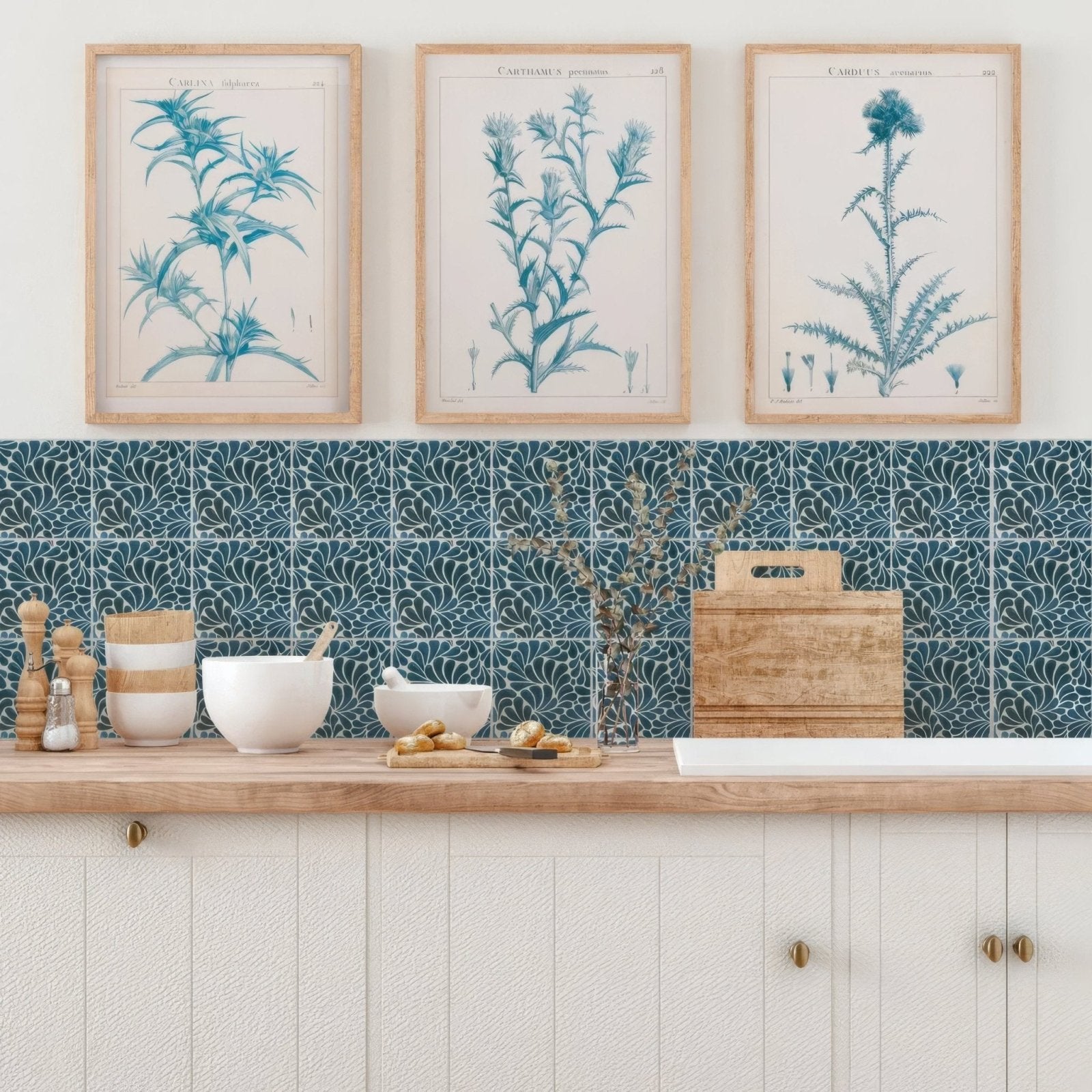 Three framed botanical prints with teal blue illustrations on cream paper in light wood frames for kelmscott emery blue tile