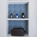 Black Armani jeans toiletry bag with repeating logo pattern and Kelmscott Emery blue patterned tile design