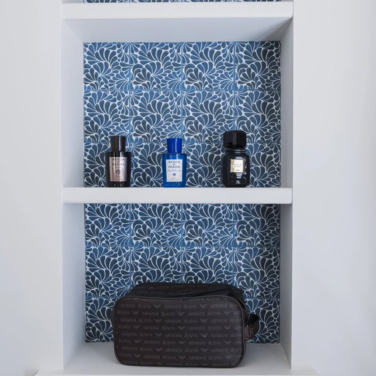 Black Armani jeans toiletry bag with repeating logo pattern and Kelmscott Emery blue patterned tile design