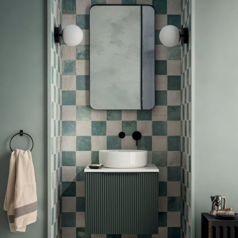 Bathroom with checkered tile wall, mirror, and sink.