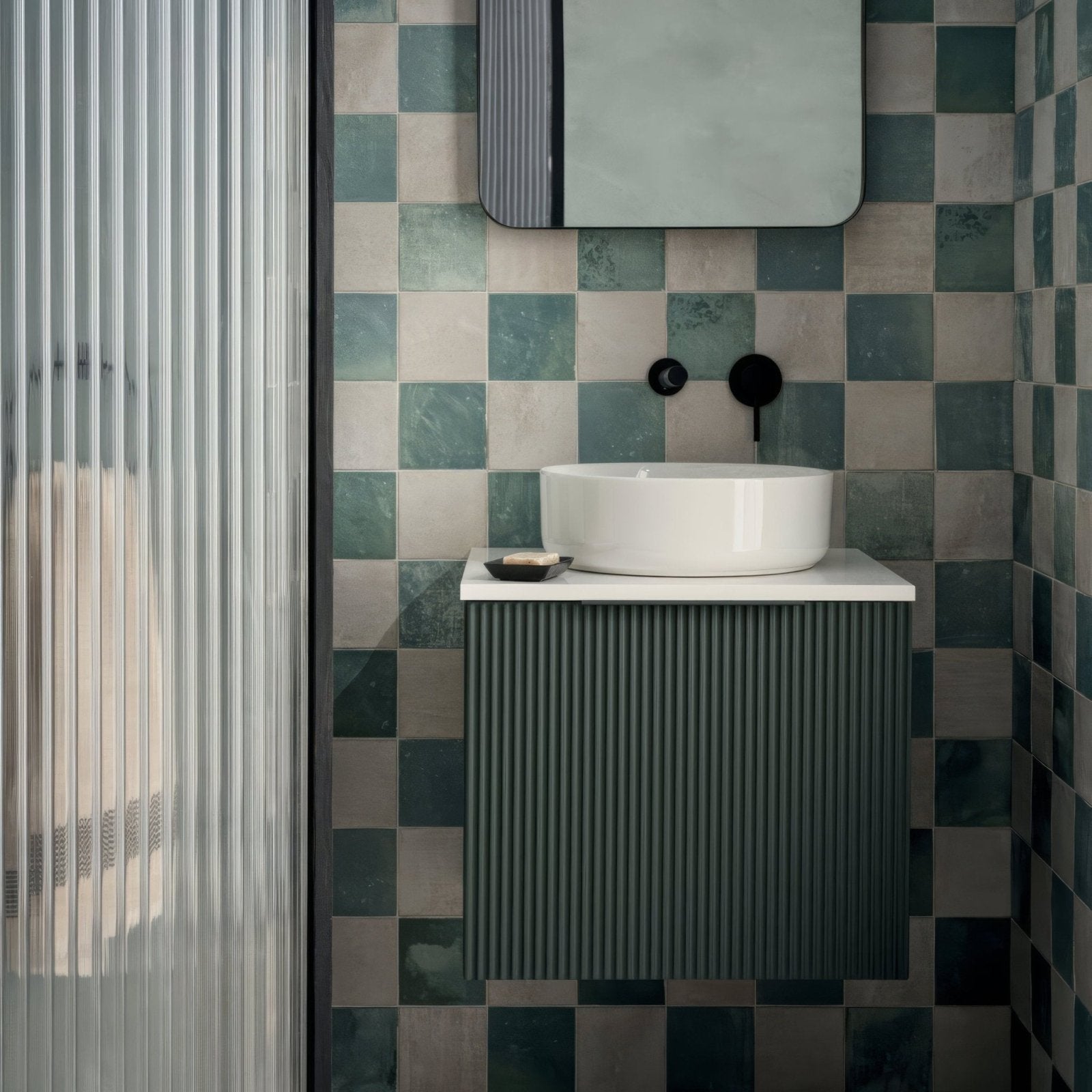 White ceramic vessel sink with sleek modern design on dark green ribbed vanity cabinet kelmscott green tile