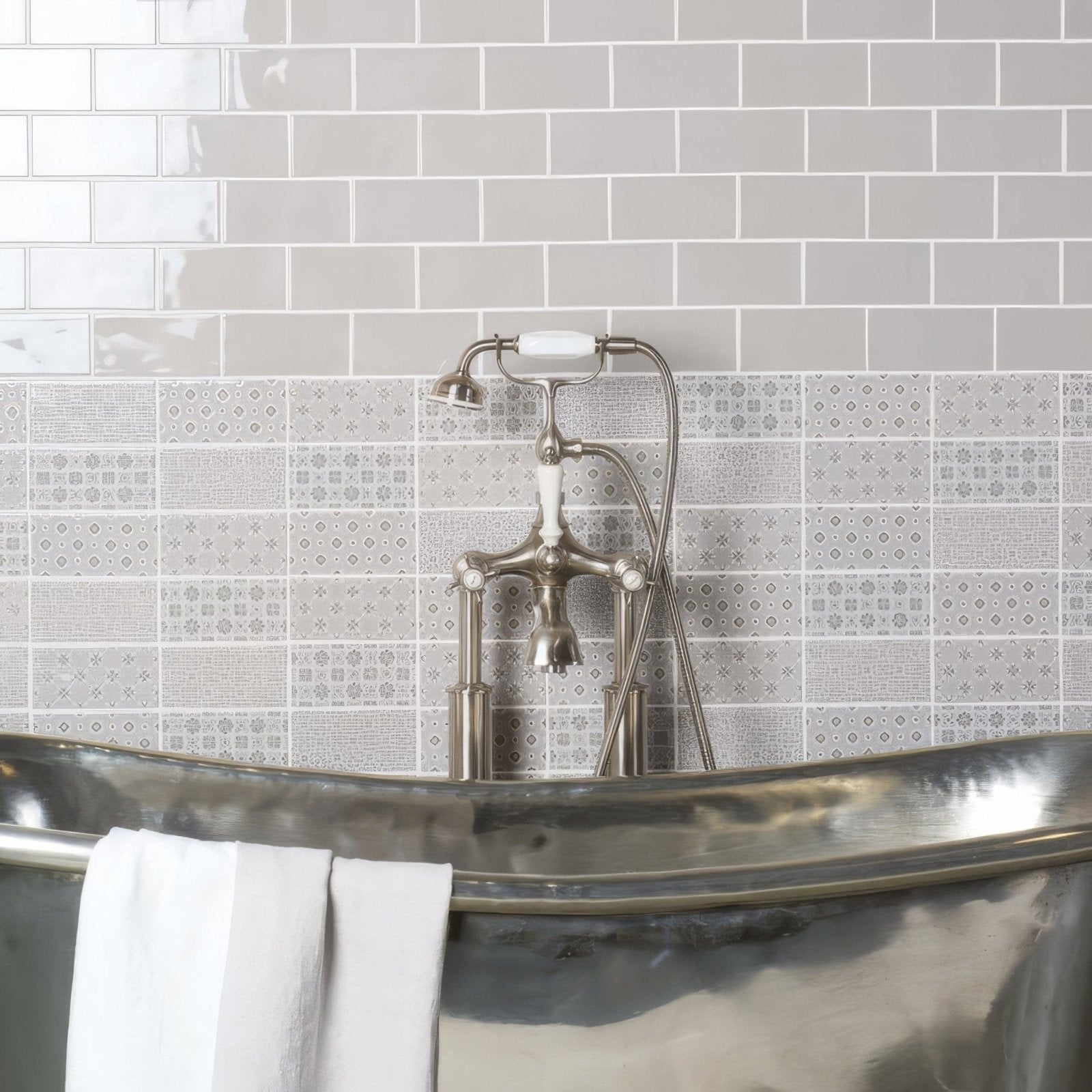Polished silver bathtub kew on dunwich with classic faucet and white towel draped over its edge