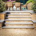 Stone steps with kimmeridge limestone tumbled and etched finish in light gray with beige brick sides