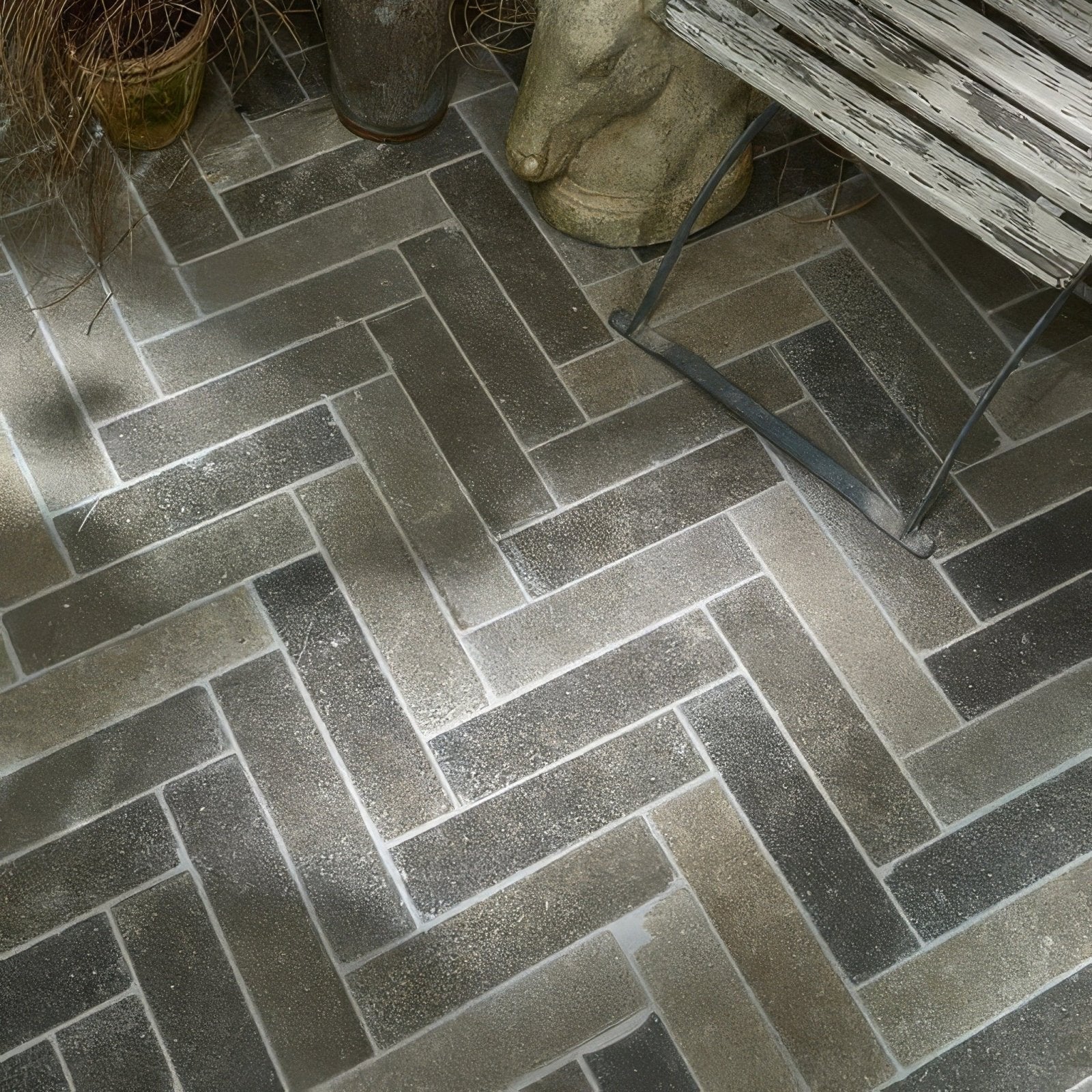 Dark gray herringbone patterned kimmeridge limestone tumbled and etched parquet floor tiles with stone-like texture