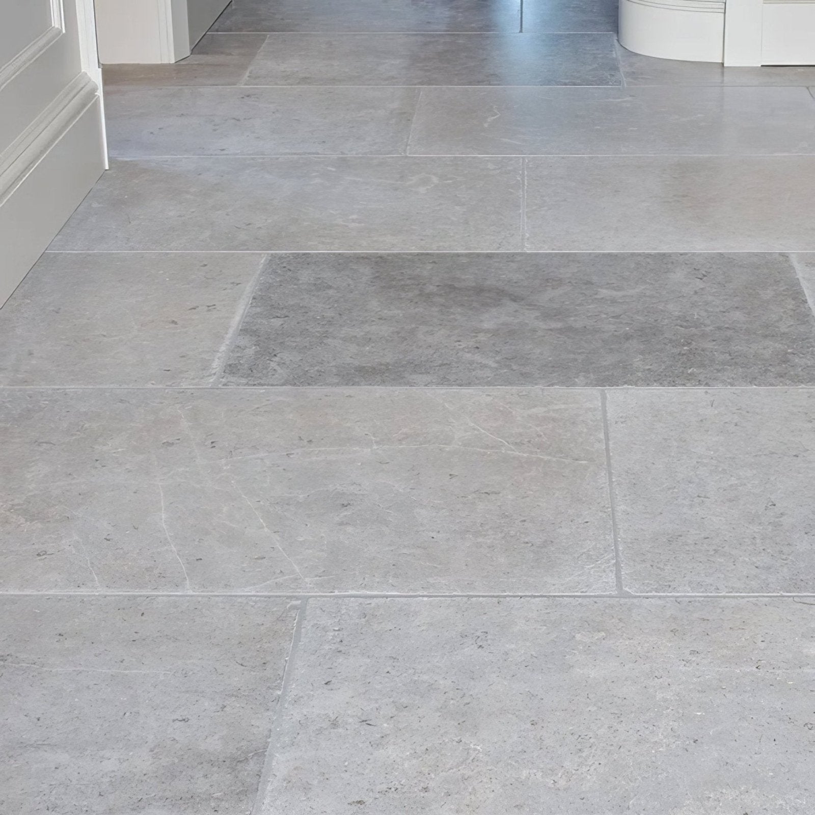 Light gray kimmeridge limestone tiles with subtle natural veining and smooth polished tumbled finish