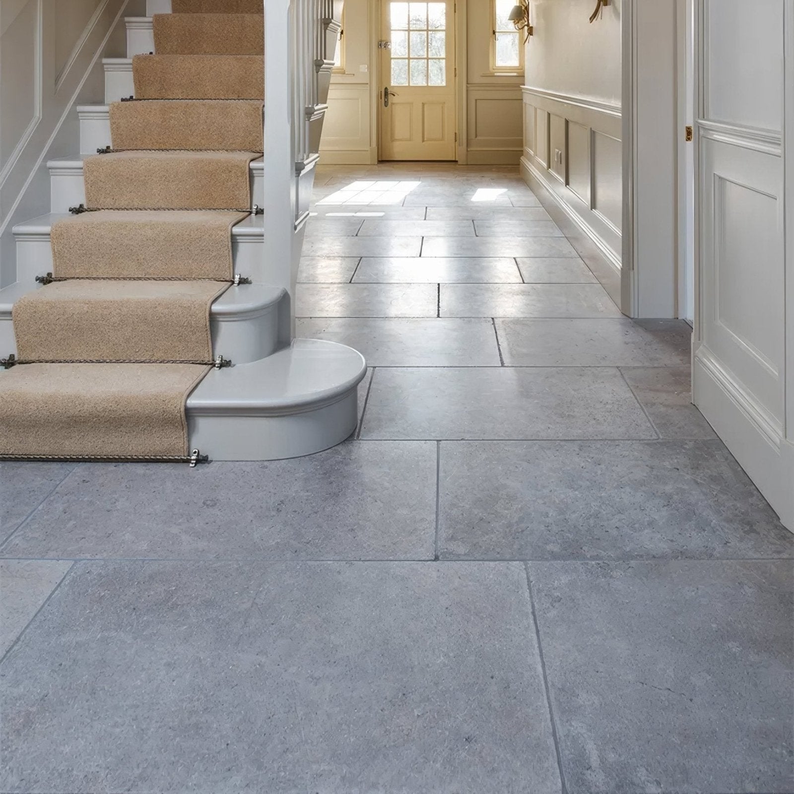 Gray kimmeridge limestone tumbled finish stone tiles with subtle texture lining a hallway floor