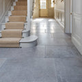 Gray kimmeridge limestone tumbled finish stone tiles with subtle texture lining a hallway floor