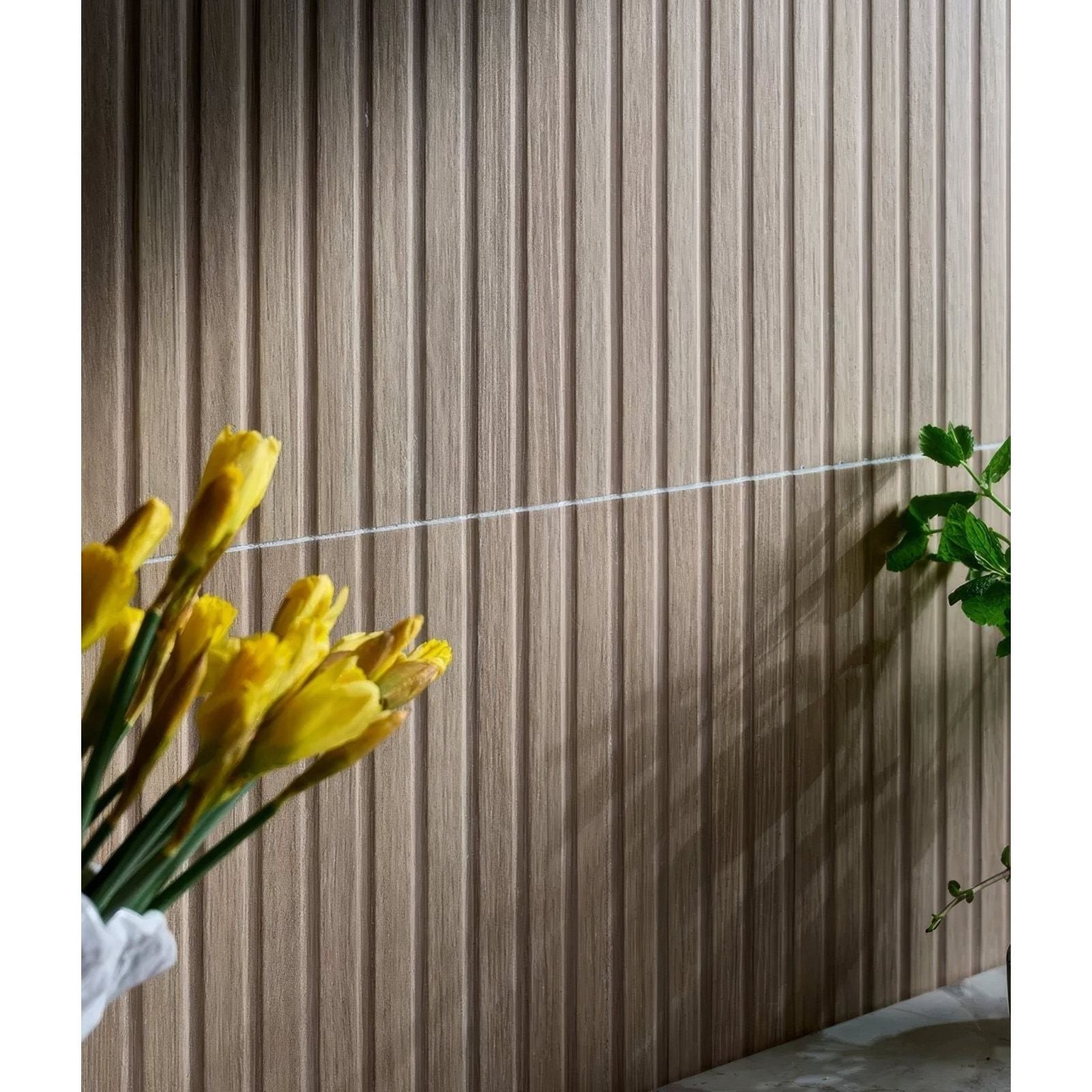 A wall featuring kinfolk porcelain maple vertical wooden paneling in a warm light brown tone