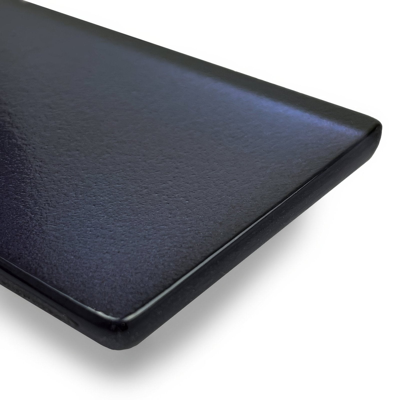 Black ceramic plate with smooth slightly textured surface and rounded edges paired with kingfisher blue glass wall tile