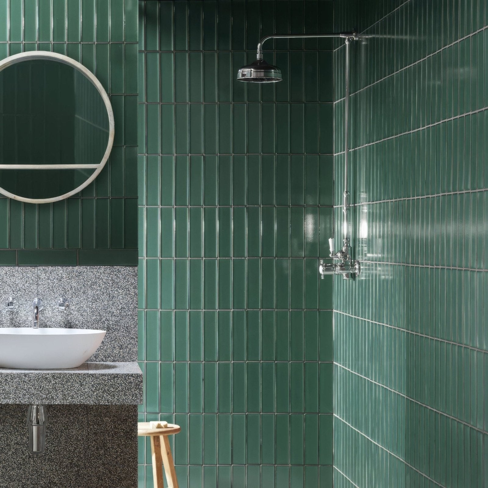 Emerald green glossy kingfisher green glass wall tiles arranged vertically covering bathroom walls