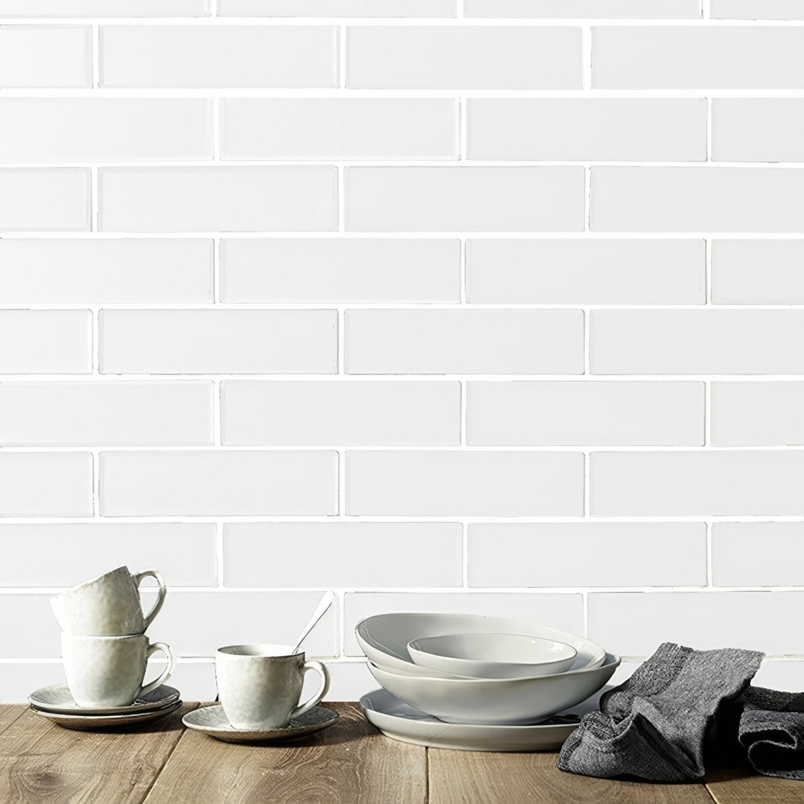 Kingfisher white glass wall tile featuring a white ceramic dinnerware set with matte finish and subtle earthy tones