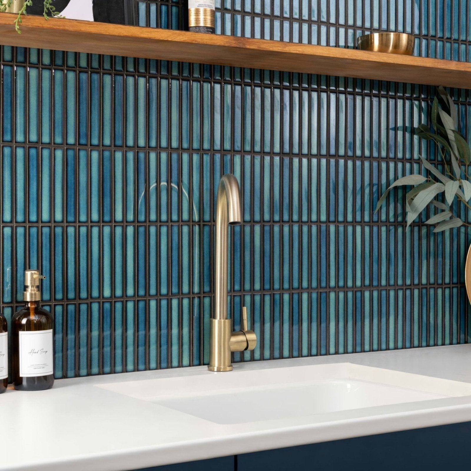 Brass faucet with a sleek curved spout in kitkat blue two tone mosaic design for modern kitchen use