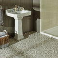 White ceramic pedestal sink with ornate detailing and chrome faucets in knightshayes light grey on chalk background