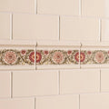 Beige ceramic tile border knot garden with pink floral pattern and green vines on county white background
