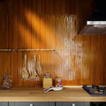 Warm amber-colored glossy vertical tiled kitchen backsplash with subtle textured finish koeda xl honey crackle