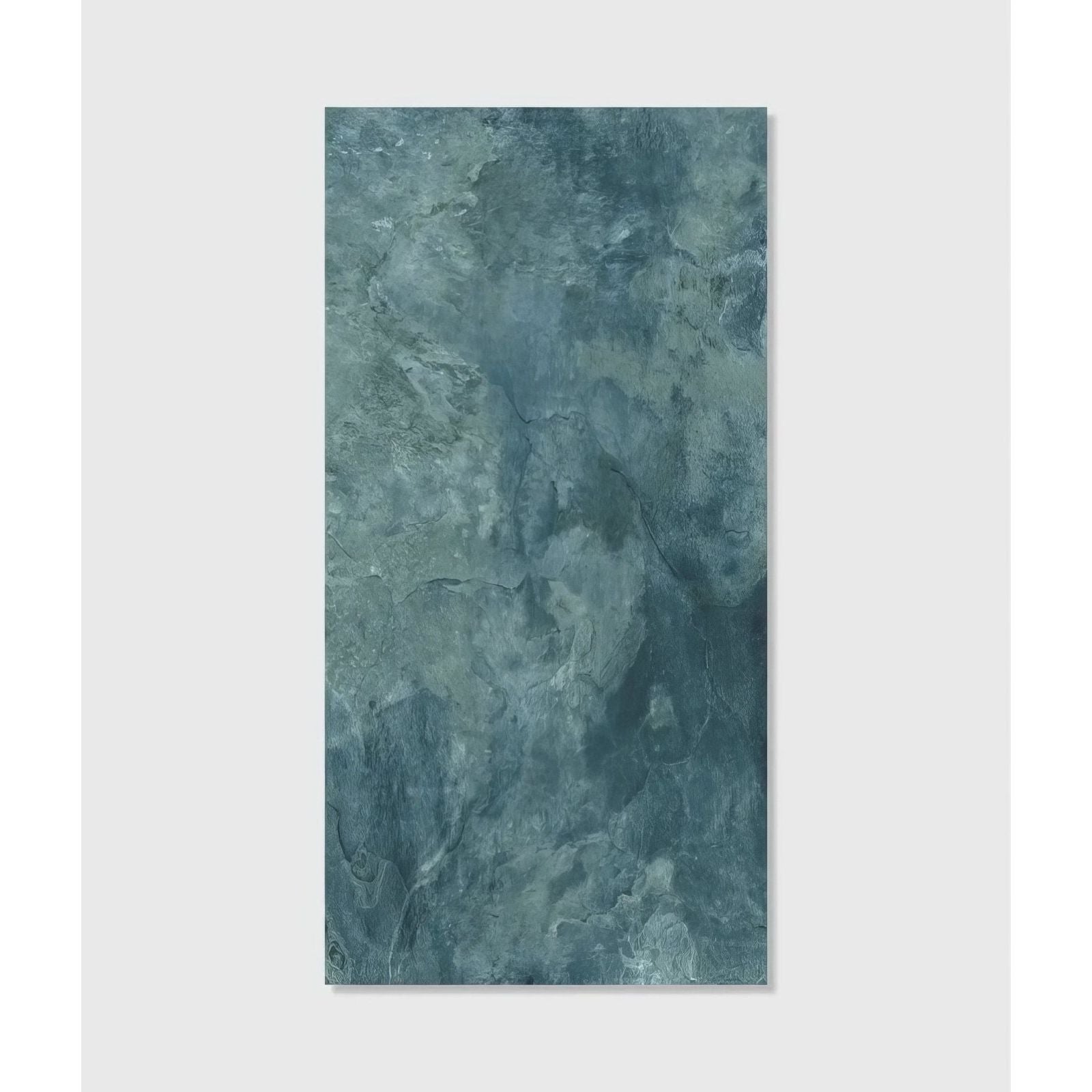 A rectangular teal blue textured porcelain wall tile with a mottled stone like surface from Komodo Porcelain Ocean