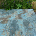 Komodo porcelain paving textured green blue and brown marble-effect patio tiles with natural veined pattern