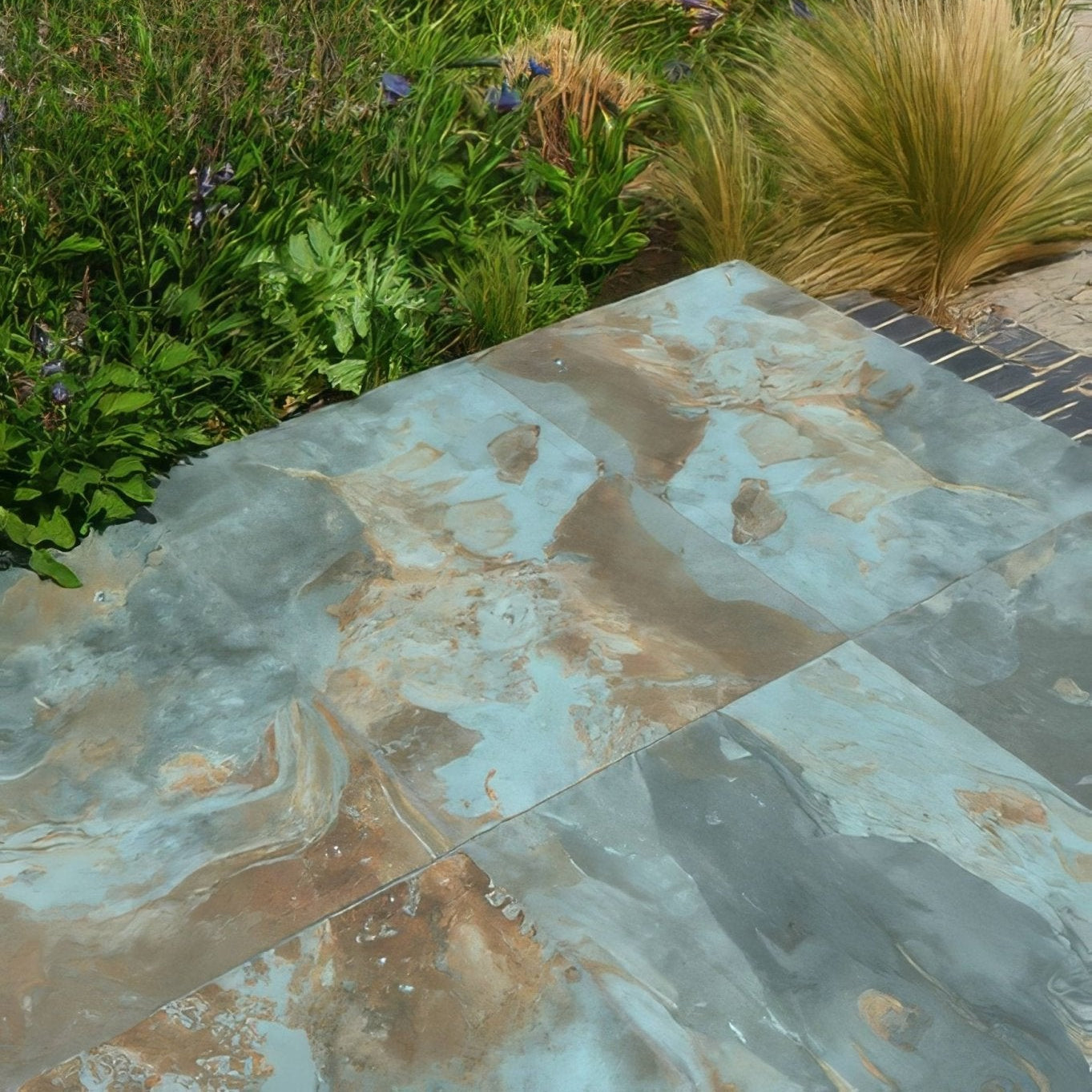 Rectangular komodo porcelain paving tiles with mottled blue and brown veining and textured green finish