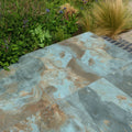Rectangular komodo porcelain paving tiles with mottled blue and brown veining and textured green finish