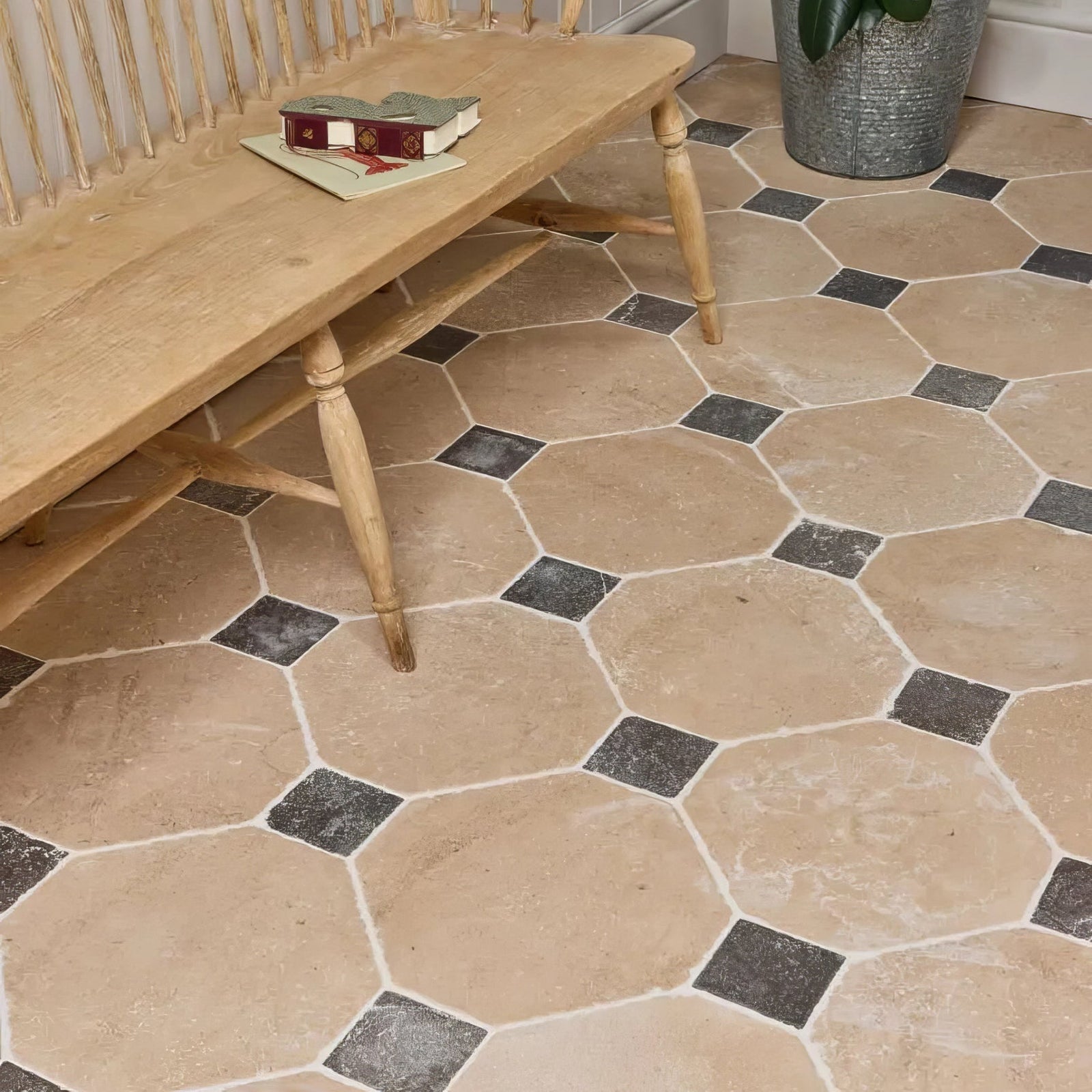 Beige and black lacock limestone heritage finish octagon and cabochons hexagonal tile floor with rustic wooden bench nearby