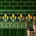 Deep green ceramic tiles with yellow tulip motifs and decorative borders from lafleur border on victorian green collection