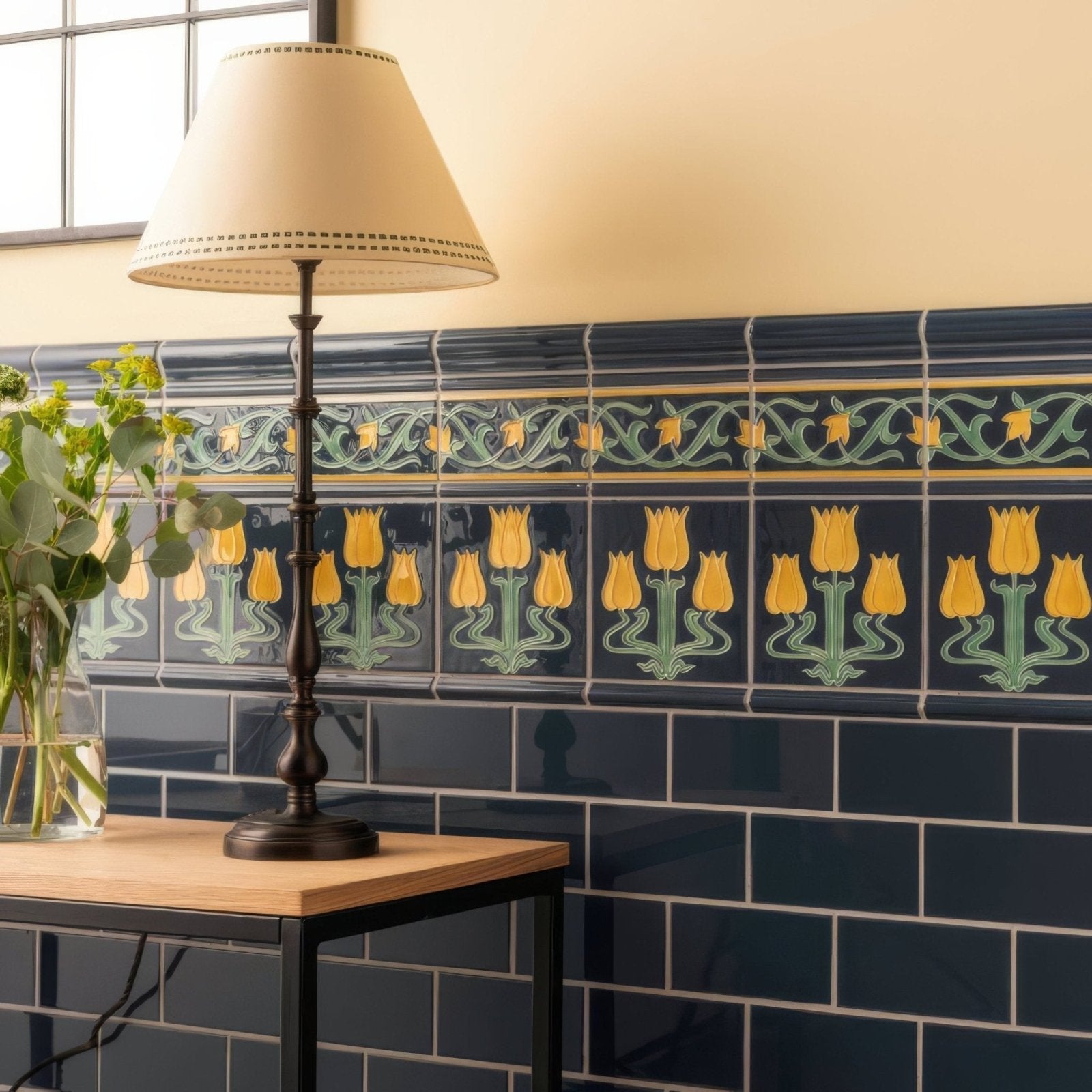 Dark blue ceramic tile wall with a decorative yellow tulip border and green vines from lafleur on ascot blue collection