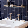 Polished chrome faucets with ornate cross handles atop white ceramic sink paired with lapis half tile wall tiles