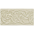 Cream-colored ceramic lavenham buckingham tile with raised ornate floral and scrollwork design