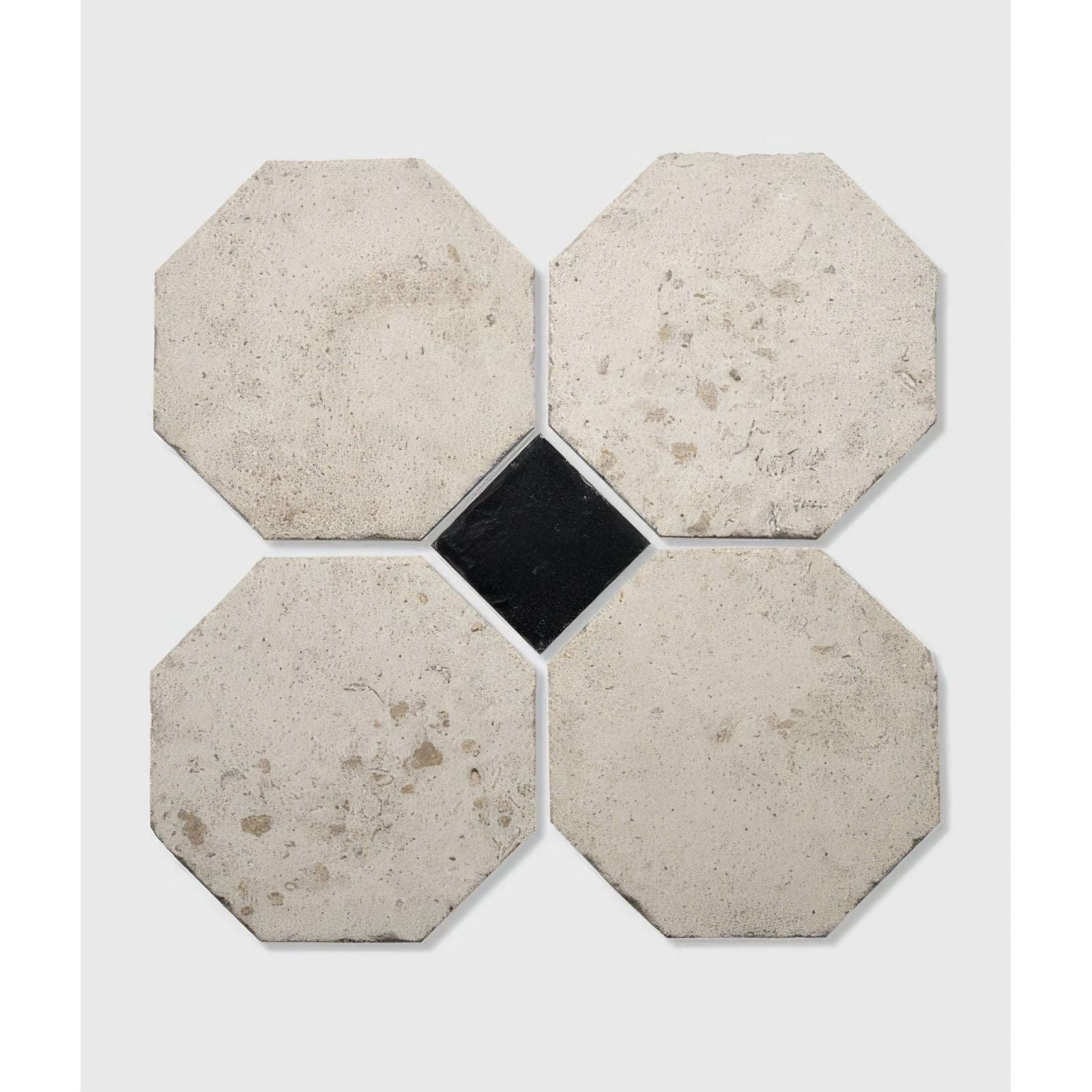 Four light gray textured limoges limestone octagonal tiles in a cross pattern with a black square tile center vintaged finish