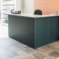 Modern dark green Lincoln Taupe Opus reception desk with vertical slat design and marble countertop