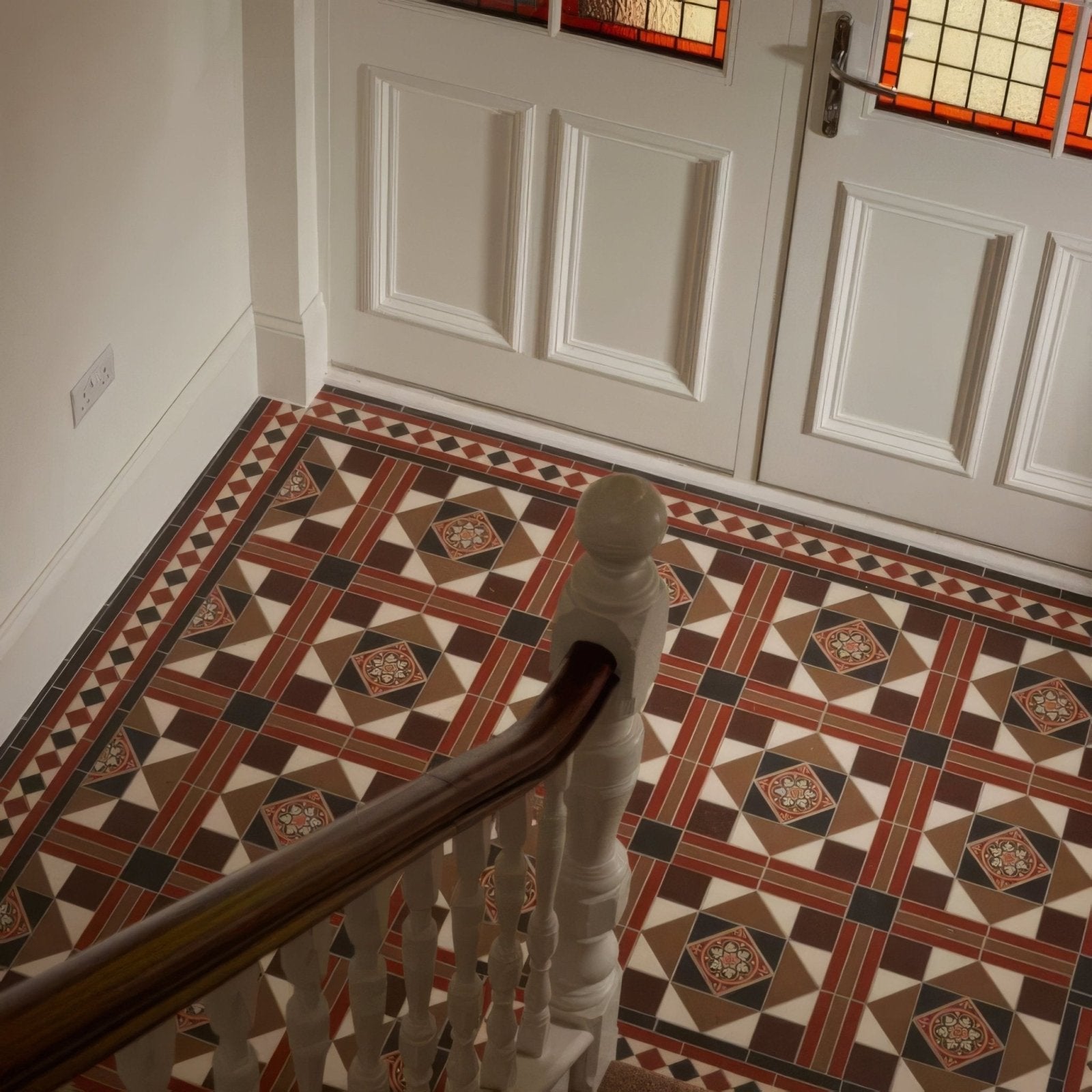The lindisfarne black brown red regency bath floor tiles feature geometric diamond patterns in livingstone green on buff