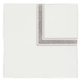 A crisp white silk pocket square with a silver geometric pattern on folded edges from linen corner grey on cotton