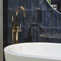 Brass-finished freestanding bathtub faucet with sleek curved spout and integrated handheld showerhead in Lisbon Blue Cobalt Shine