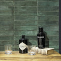 Black glass bottle of hendricks gin with diamond shaped label and silver lettering in lisbon green jade shine product