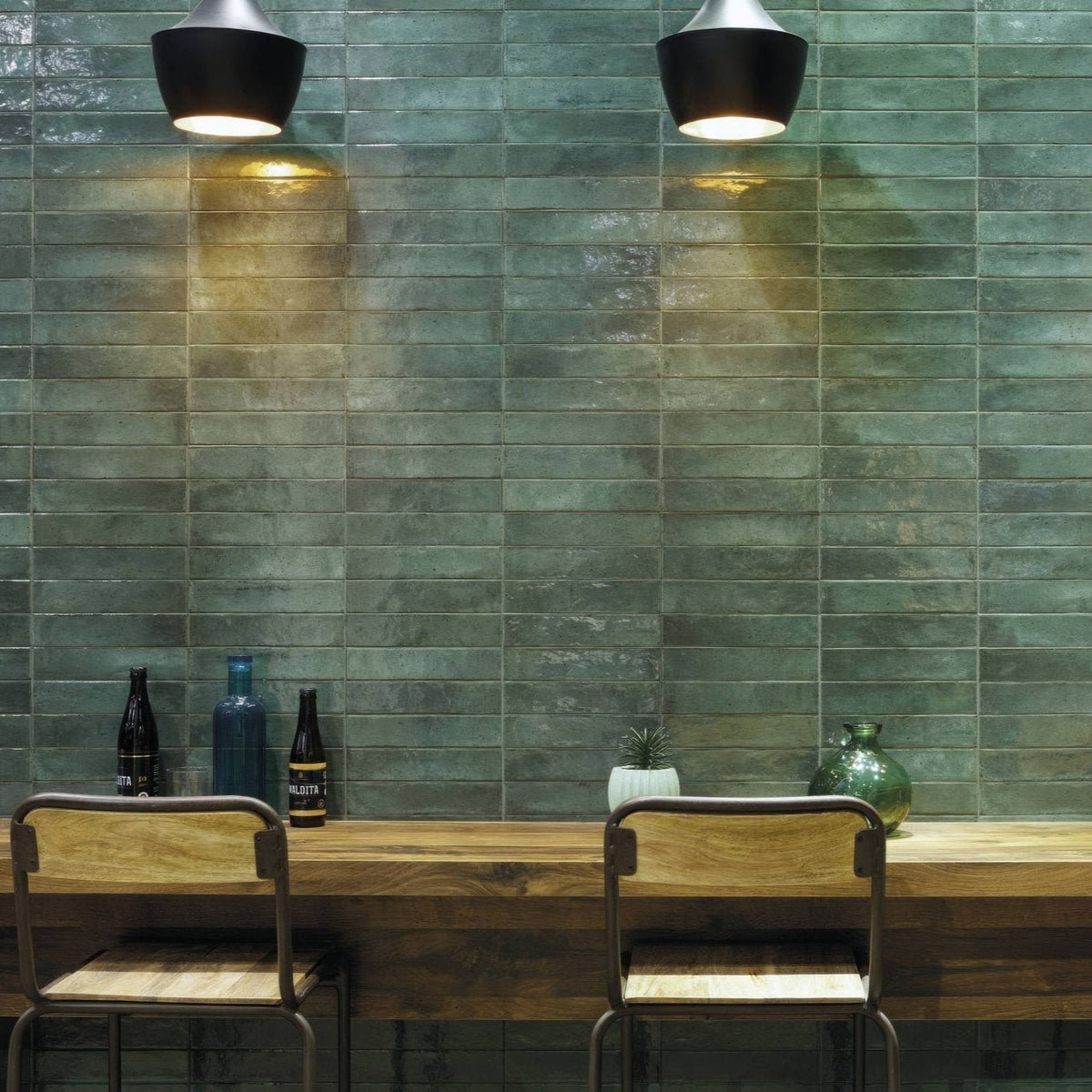Green rectangular ceramic tiles with a matte textured finish forming a wall in Lisbon green jade shine design