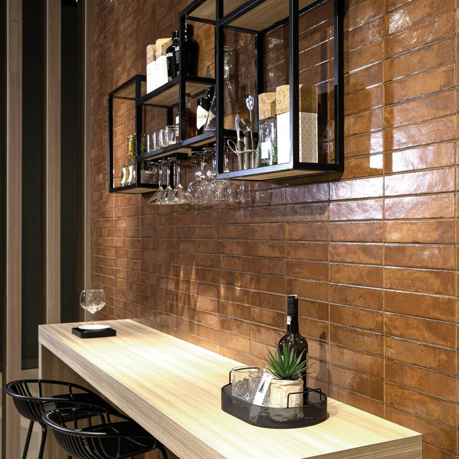 Black metal wireframe shelving unit with glass panels displaying wine bottles and glasses against a brick wall
