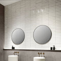 Two round mirrors with thin black frames mounted on white tiled wall featuring Lisbon warm white shine finish