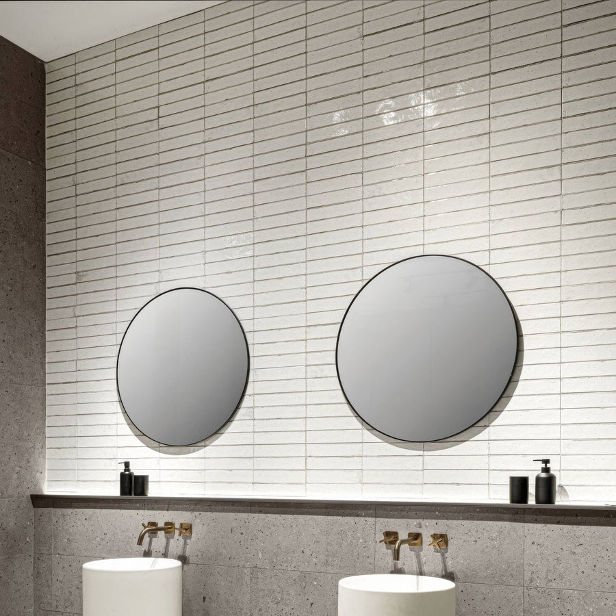 Two round mirrors with thin black frames mounted on white tiled wall featuring Lisbon warm white shine finish