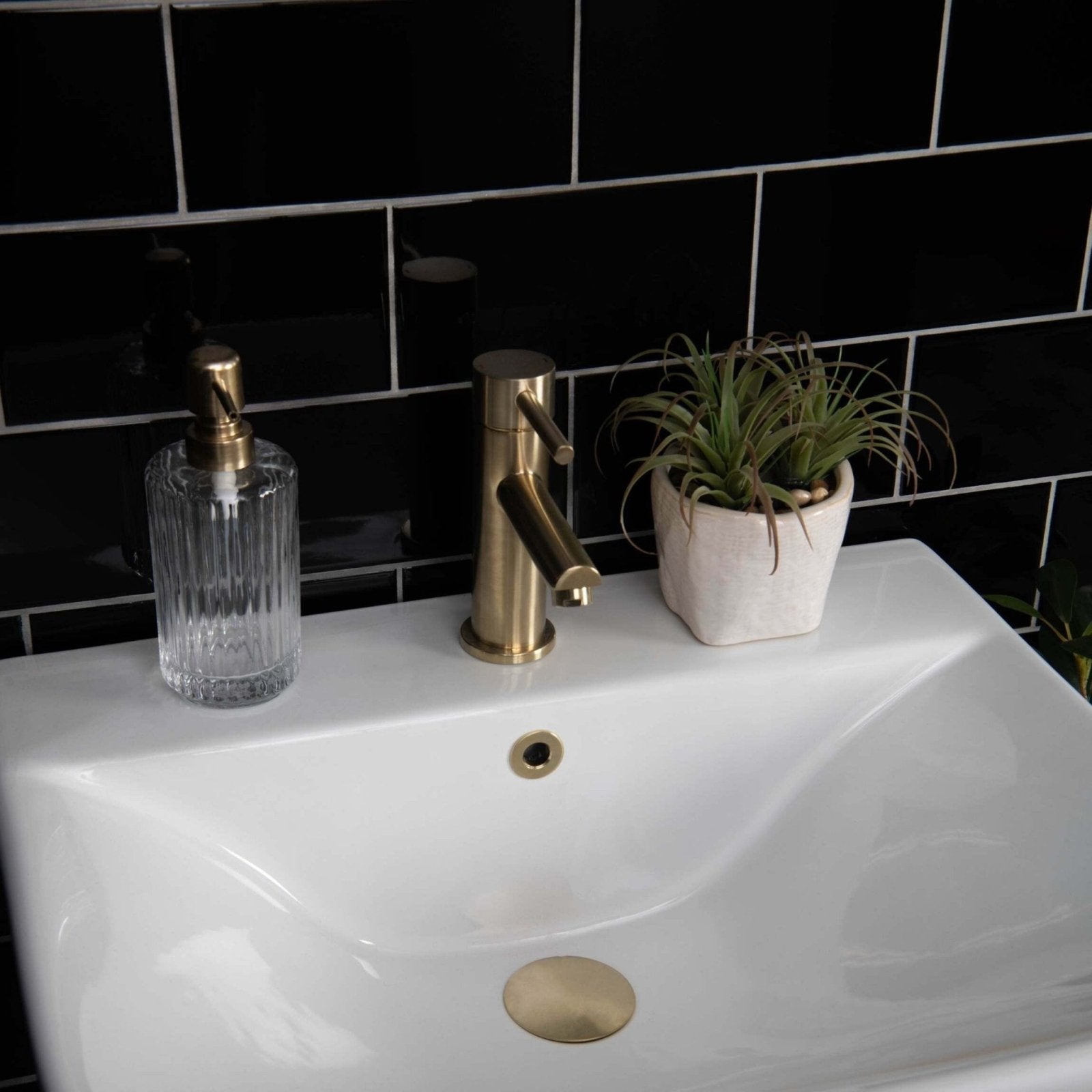Gold-toned faucet with sleek modern design and brushed metal finish on liso black gloss 100x200 bathroom fixture