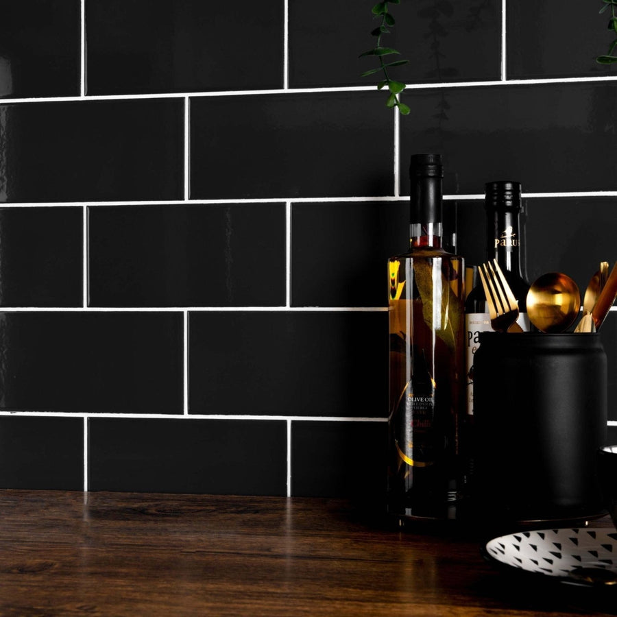 A tall slender bottle of liso black gloss olive oil with black cap and reflective amber glass