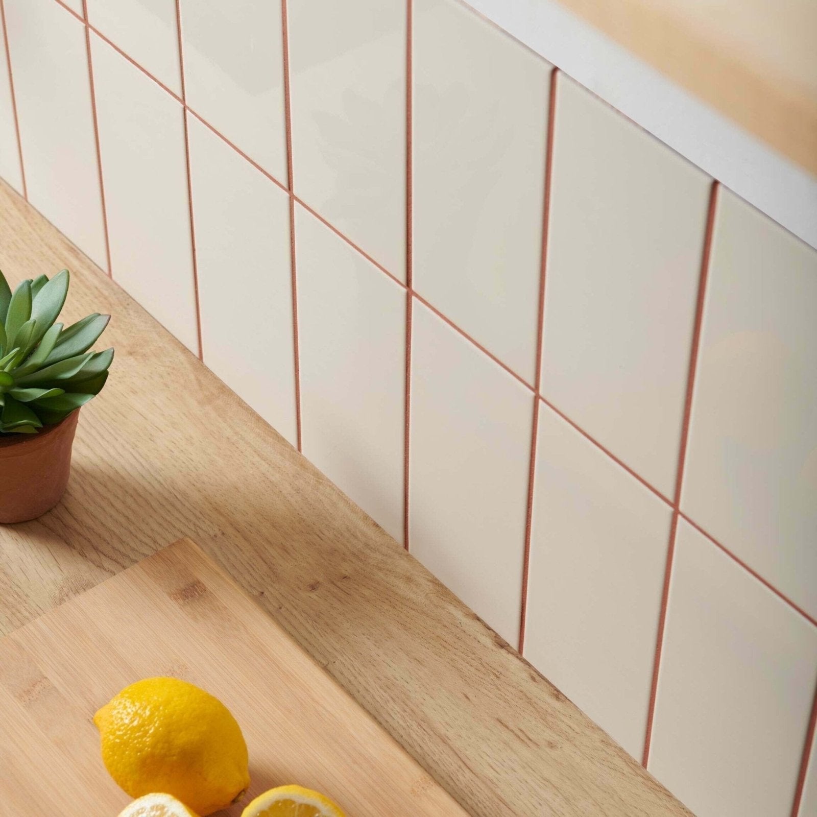 Cream-colored rectangular liso bone gloss 100x200 tiles with thin rose gold grout lines for elegant wall use