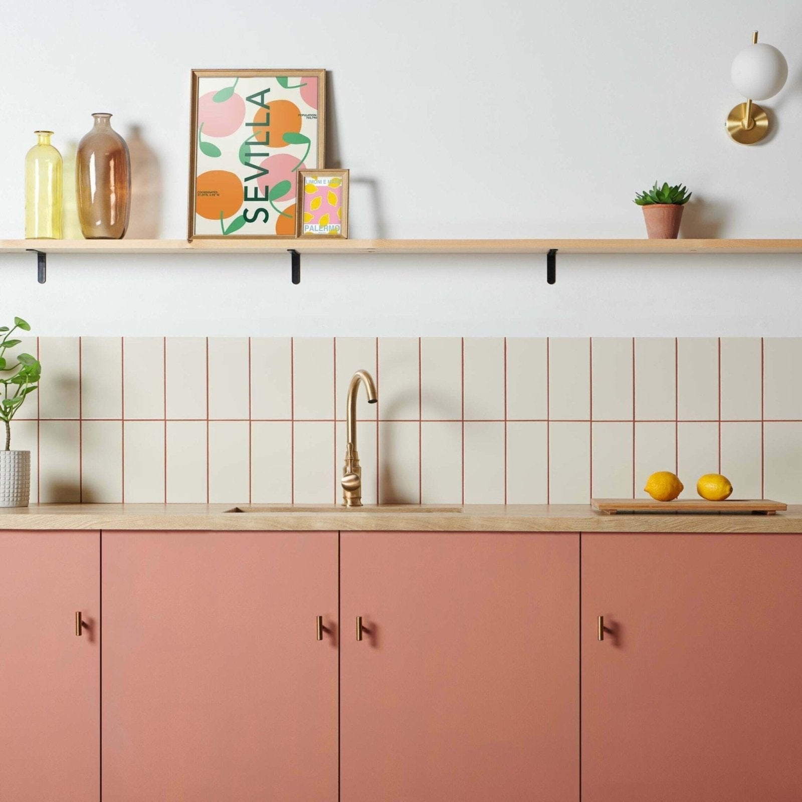 Modern kitchen with liso bone gloss 100x200 beige subway tiles featuring thin red grout lines and pink cabinets with gold faucet