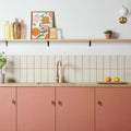 Modern kitchen with liso bone gloss 100x200 beige subway tiles featuring thin red grout lines and pink cabinets with gold faucet